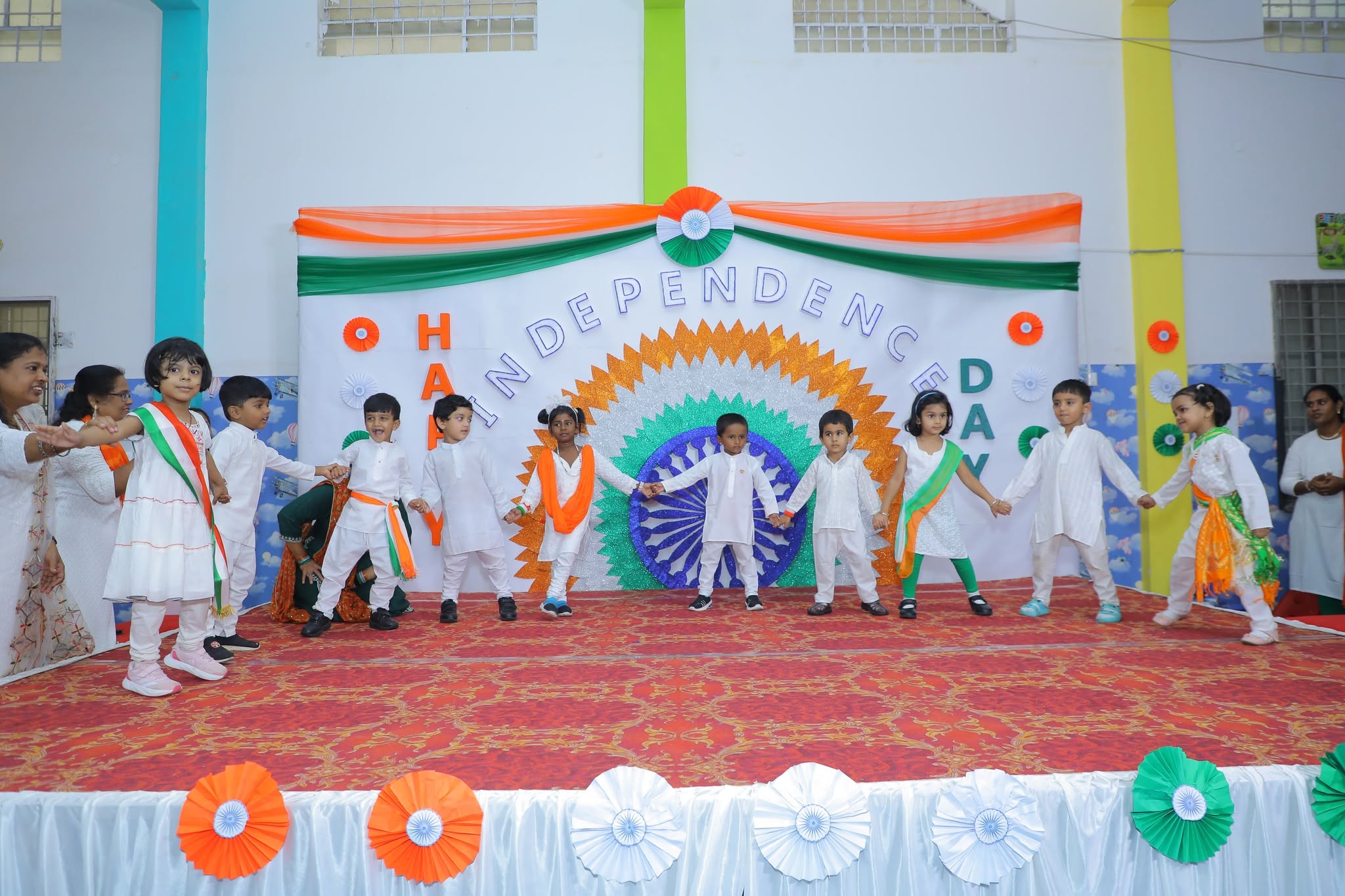 Children performing together on stage at a school celebration
